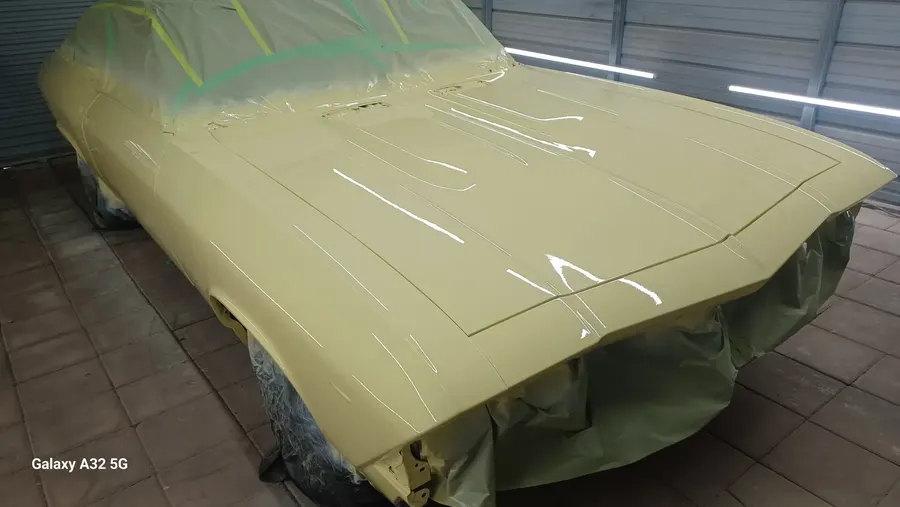 Cream classic car masked in paint booth
