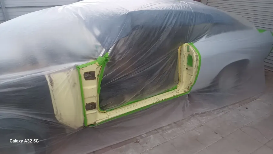 Green classic car masked for paint prep