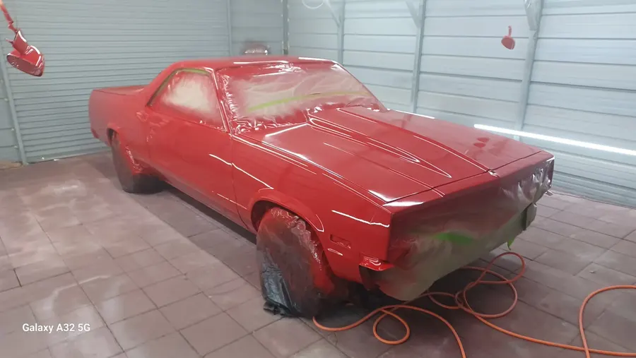 Red muscle car fresh paint in booth