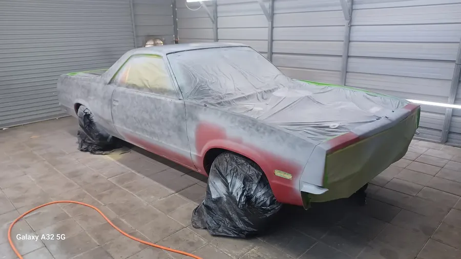 Red muscle car masked in primer