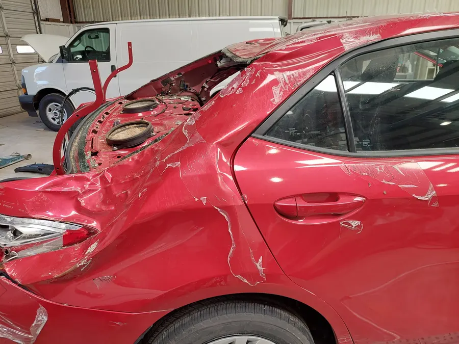 Red sedan rear quarter collision damage