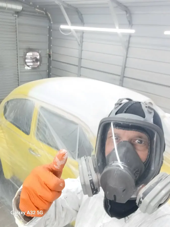 Yellow VW Beetle masked during paint spray
